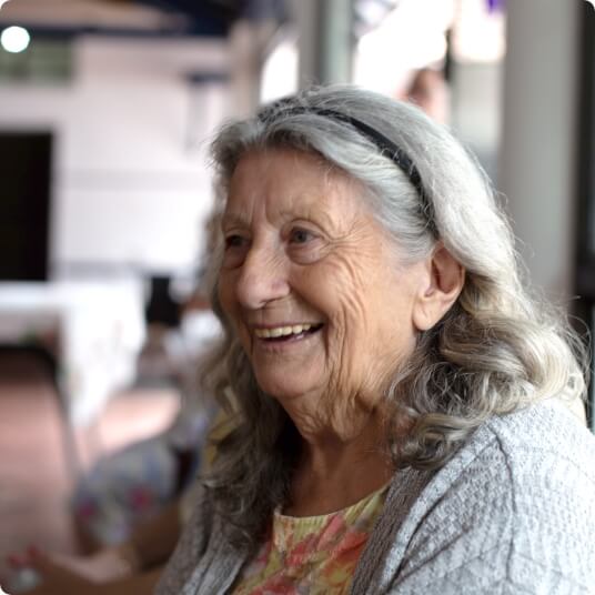 A senior woman laughing in profile